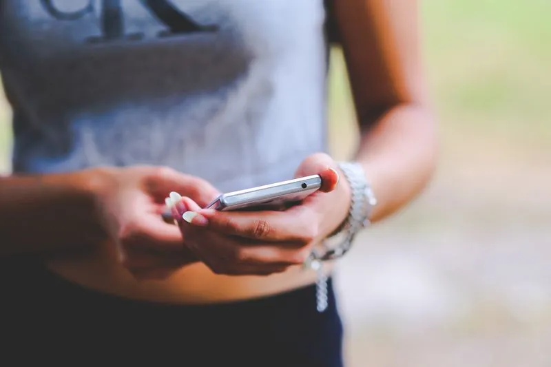 Två händer som håller i en mobiltelefon