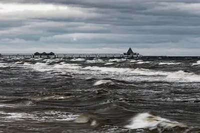 Kraftiga vågor som bryter under en dramatisk stormhimmel