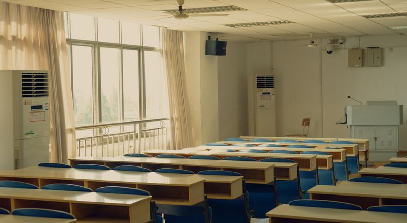 Rader av bänkar och stolar i ett tomt klassrum