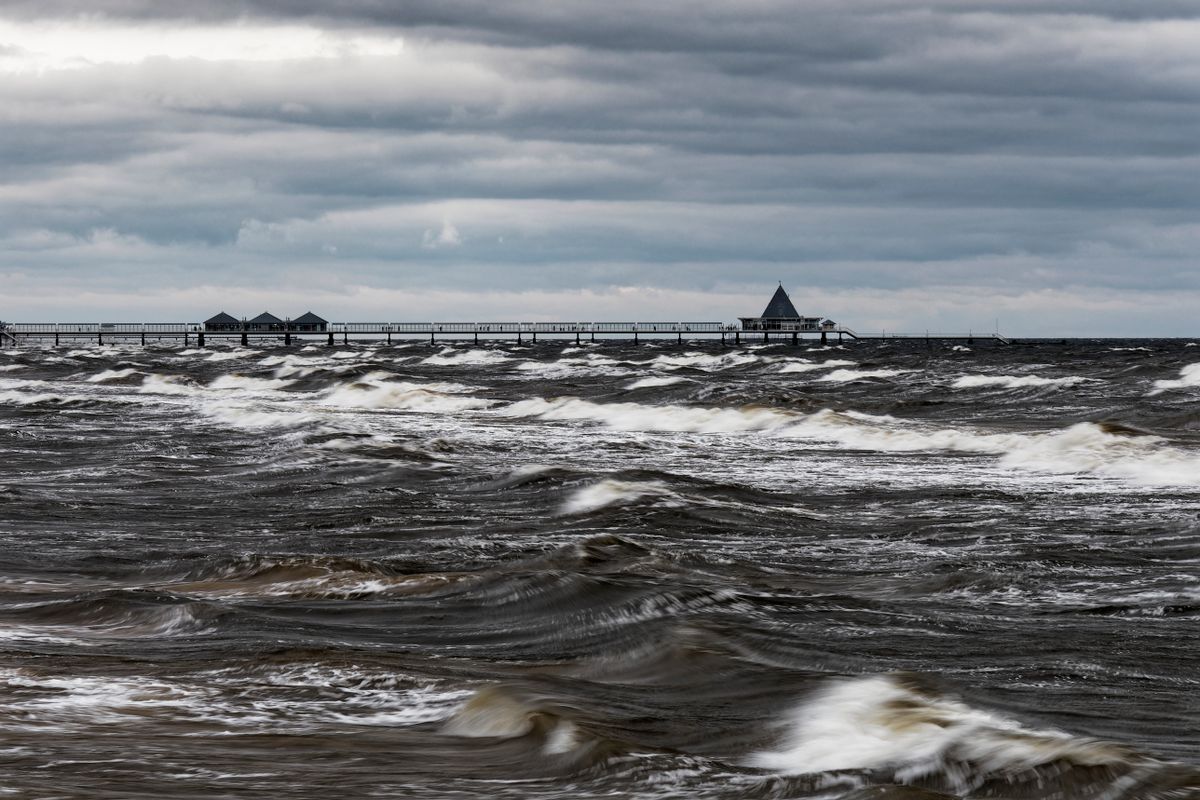 Kraftiga vågor som bryter under en dramatisk stormhimmel