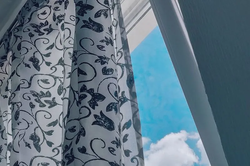 Ett öppet fönster med fladdrande gardin