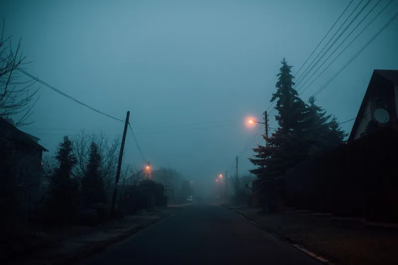 En dimmig villagata i skymningen